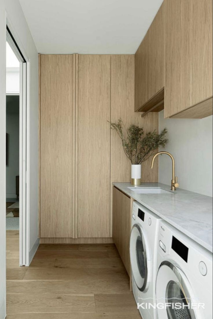 a washer and dryer in a room with wood paneling on the walls