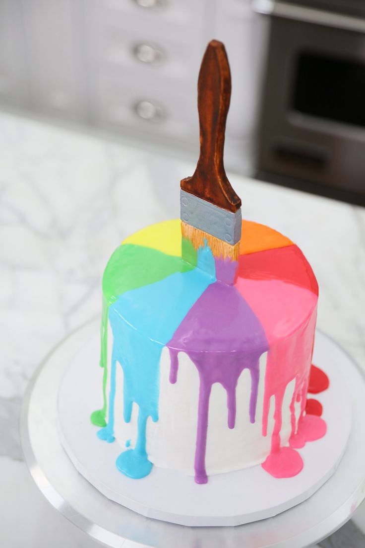 a colorful cake with a paintbrush on top