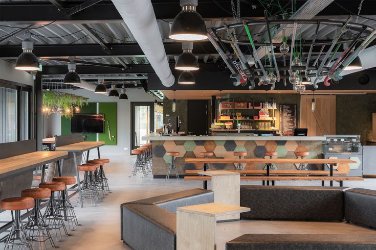 the interior of a restaurant with tables and stools, bar tops, and bars