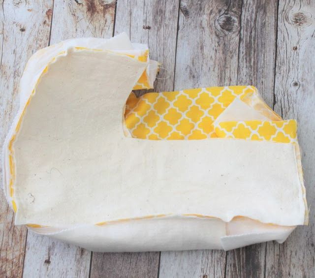 a piece of cloth with yellow and white designs on it sitting on a wooden surface