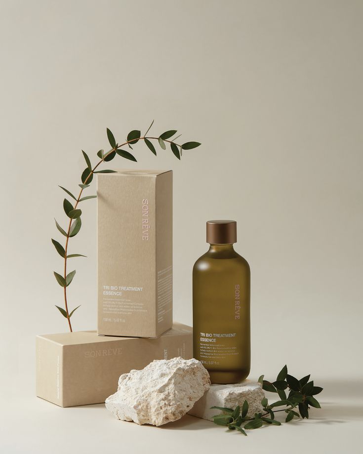 a bottle of lotion next to some rocks and a box with a plant on it