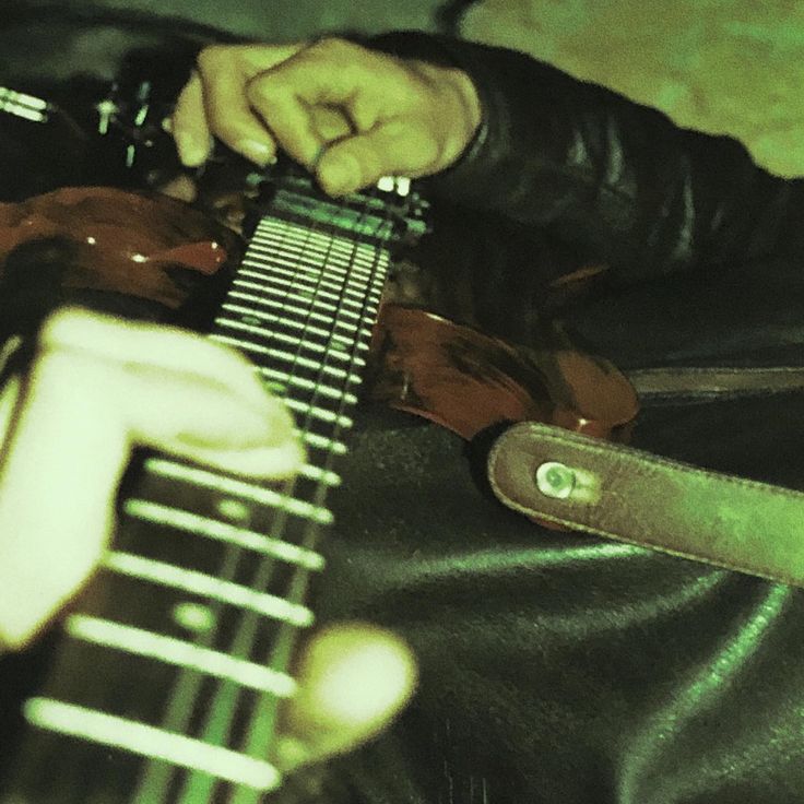 a person playing an electric guitar with their hands