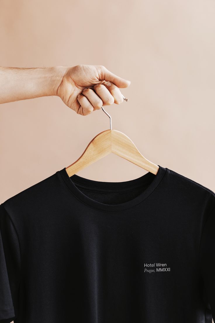 a person is holding a t - shirt on a hanger with the word human nature printed on it