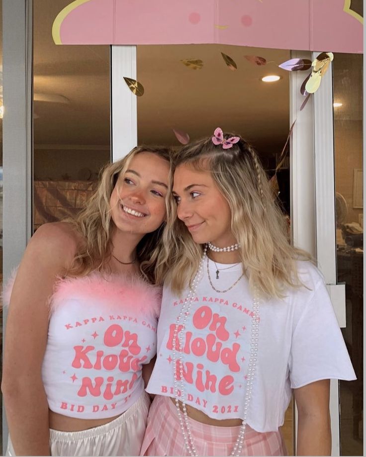 two young women standing next to each other in front of a door wearing matching shirts