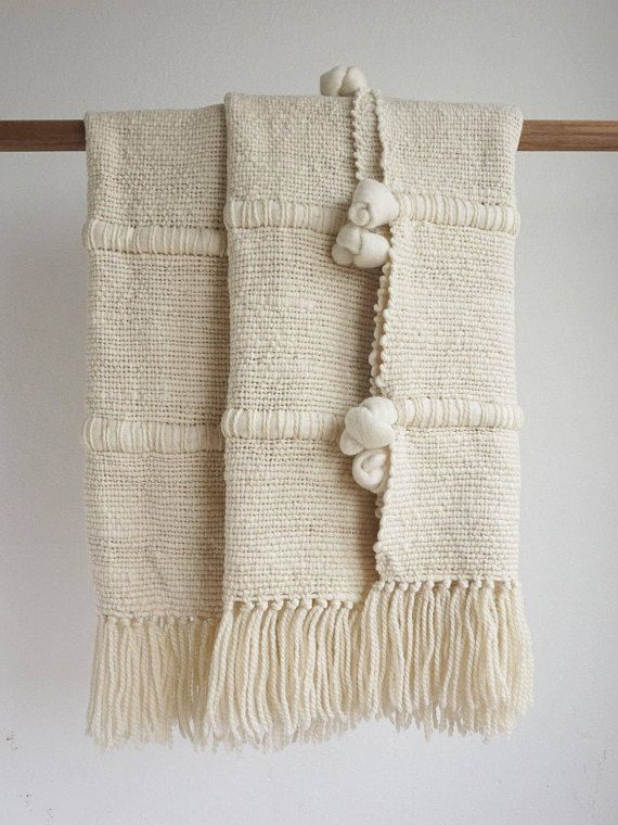 two white towels hanging on a wooden rack