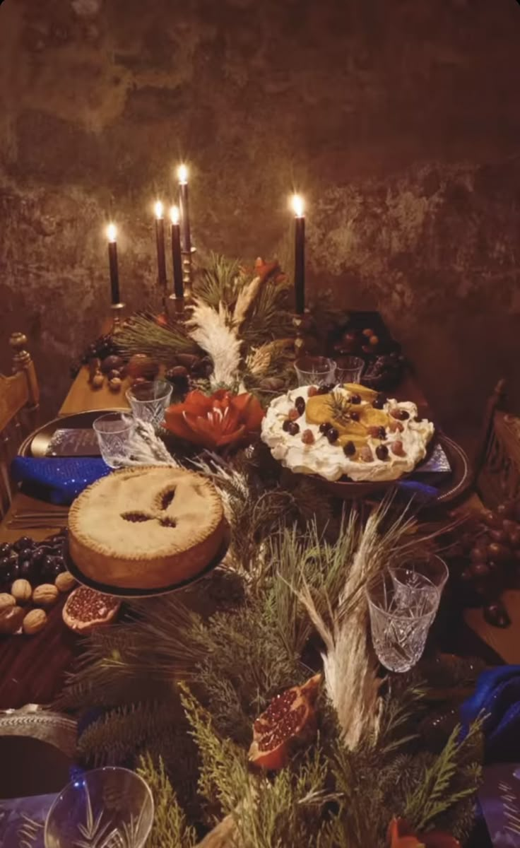 a table topped with lots of food and candles