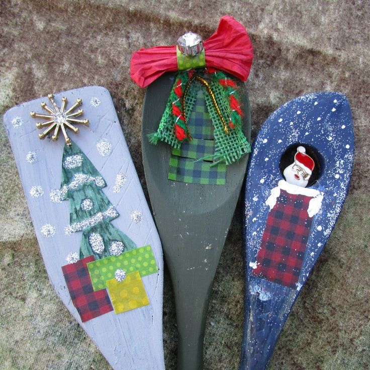 three wooden spoons decorated with christmas decorations