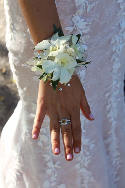 a woman in a wedding dress holding a bouquet of flowers and two rings on her hand