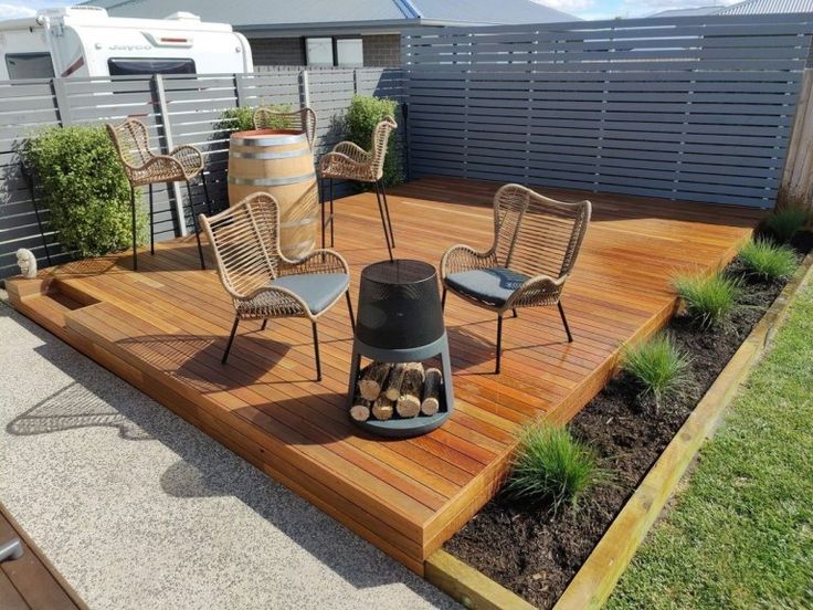 an outdoor deck with chairs and fire pit