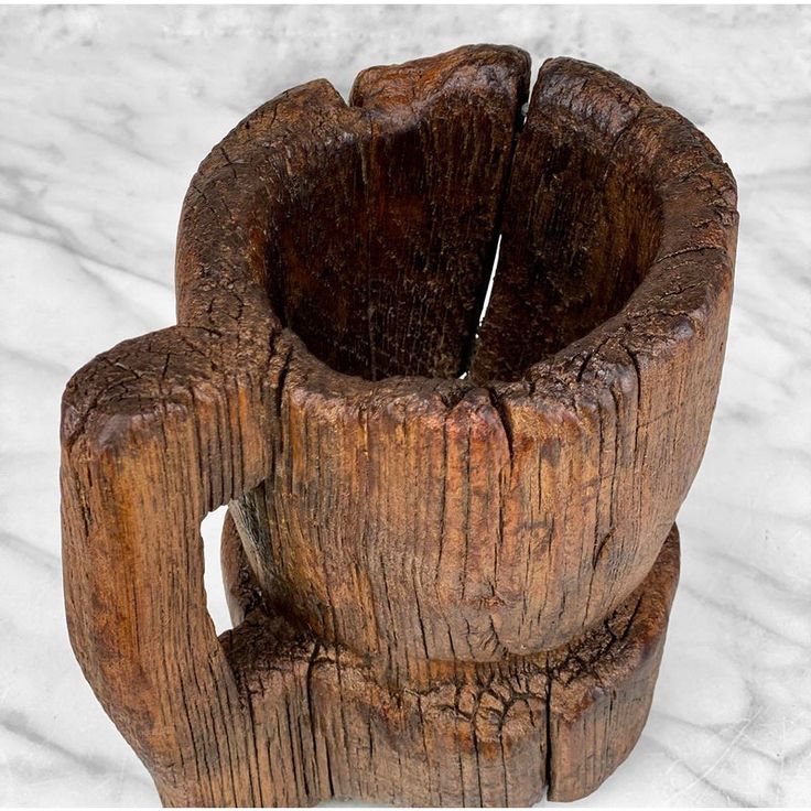 a close up of a wooden object on a white surface with snow in the background