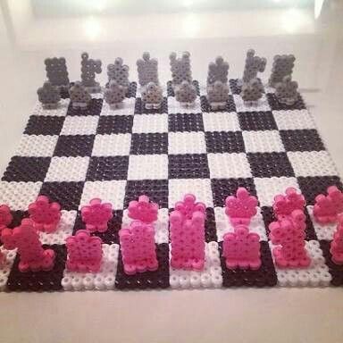 a chess board made out of legos with pink and black pieces