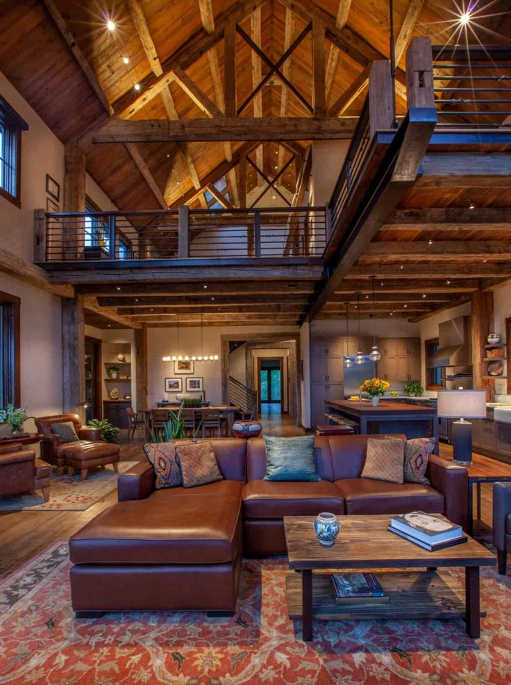 a living room filled with lots of furniture next to a fire place and wooden ceiling