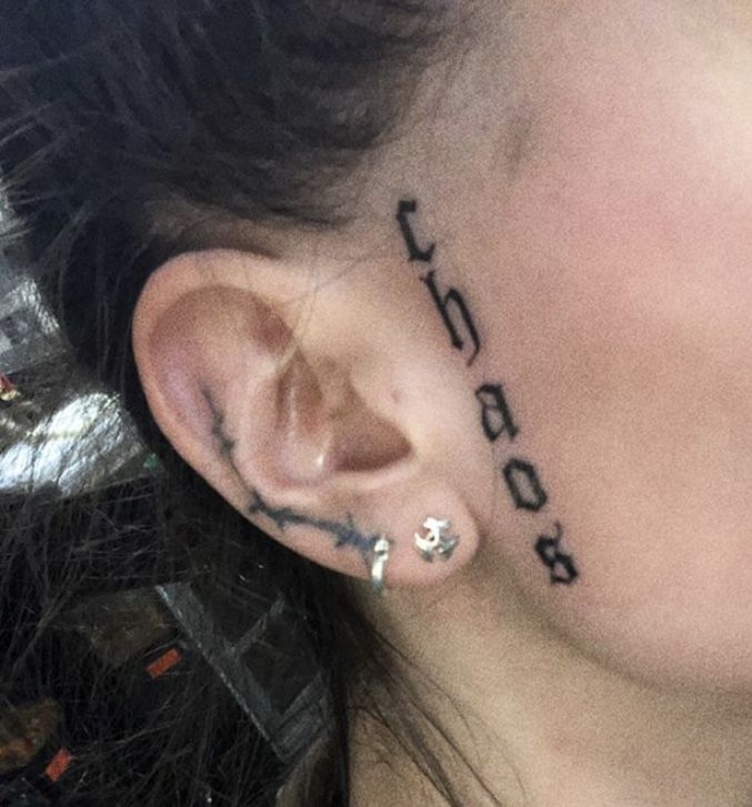 a woman with black writing on her face behind the ear