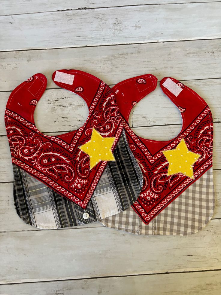 two red bandannas with yellow stars on them sitting on top of a wooden floor