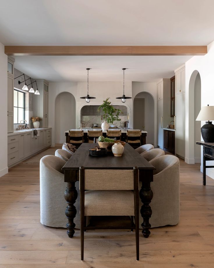 a dining room table with chairs around it and an island in the middle of the room