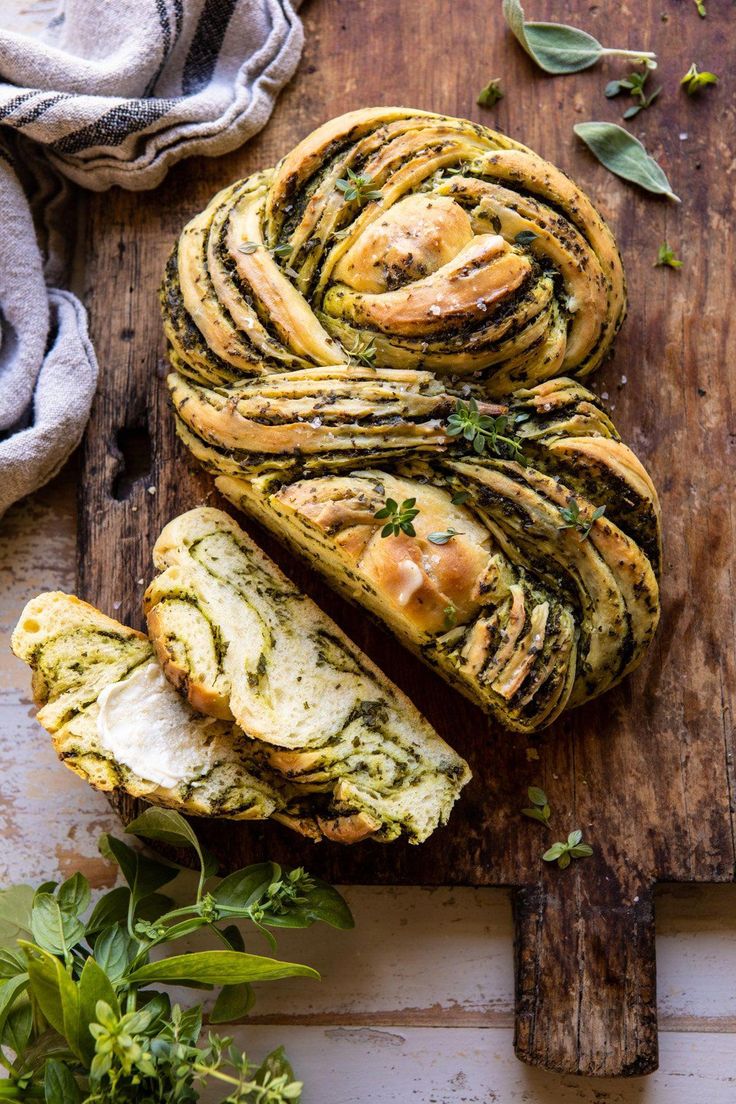 an artisan bread with pesto and cheese on top is cut in half to look like spirals