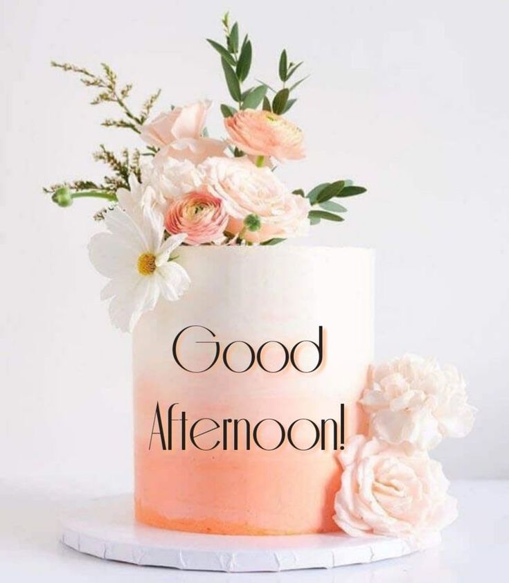 a white and pink cake with flowers on top that says good afternoon in black lettering