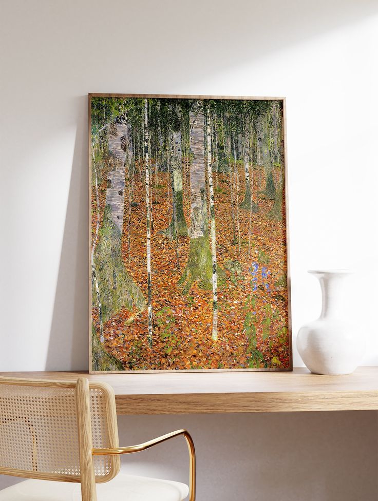 a painting on the wall above a desk with a chair and vase in front of it