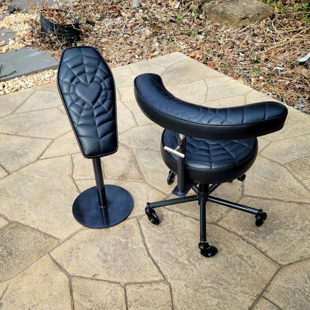 two black office chairs sitting on top of a stone floor next to eachother