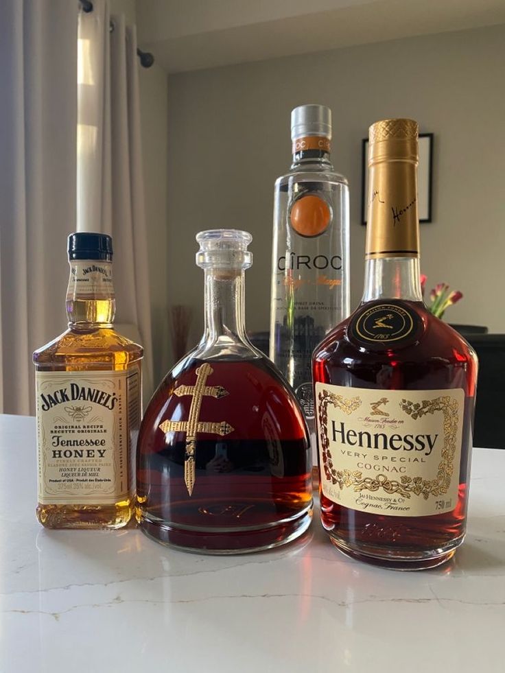 three bottles of liquor sitting on top of a counter