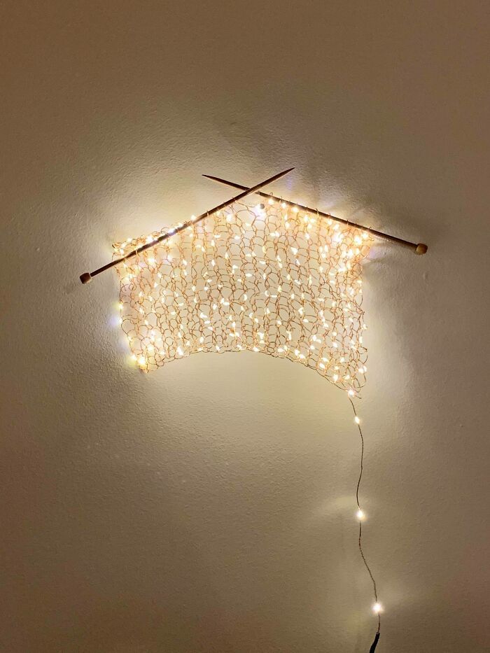 a wall mounted light fixture with lights on it's side and two sticks sticking out of the ceiling