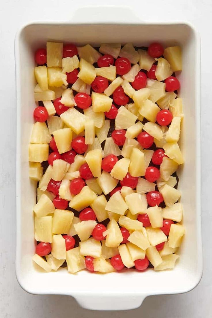 pineapple and cherries in a white casserole dish, ready to be eaten