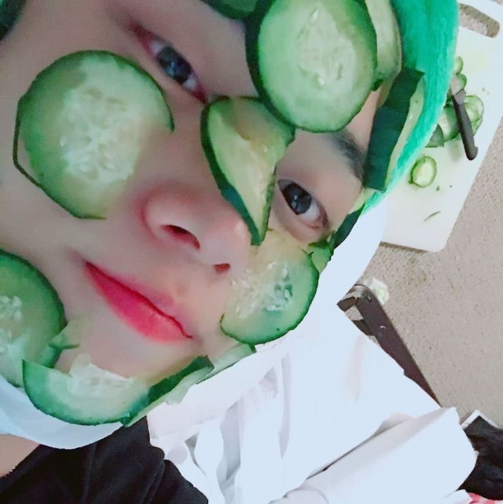 a young boy with cucumber slices on his face