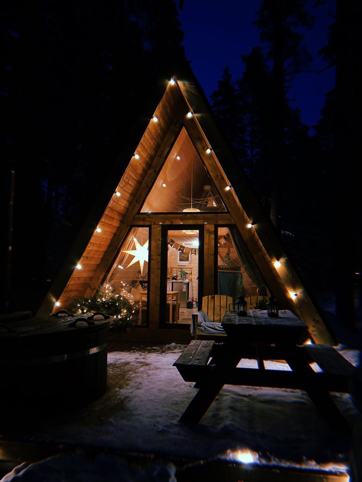 a small cabin is lit up with christmas lights