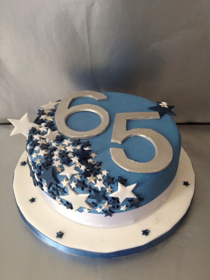 a blue and white 50th birthday cake with stars on it's side, sitting on top of a table