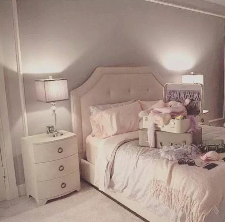 a bedroom with a bed, dresser and two lamps