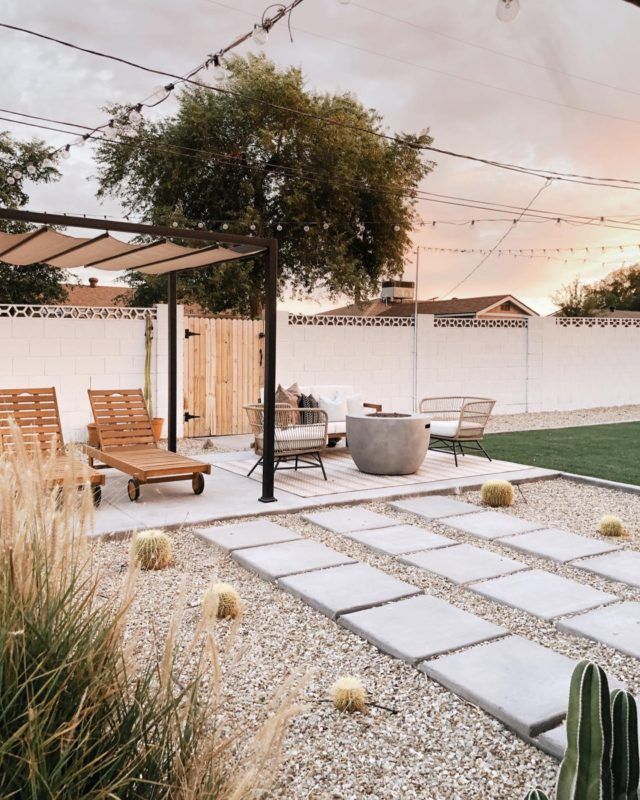 an outdoor patio with seating and plants in the foreground, surrounded by graveled walkways