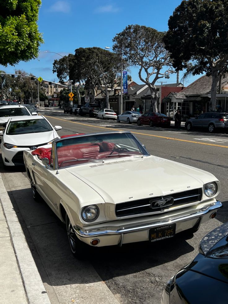 an old car is parked on the side of the road