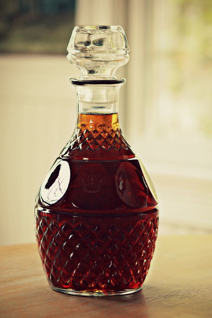 a glass bottle filled with liquid sitting on top of a wooden table