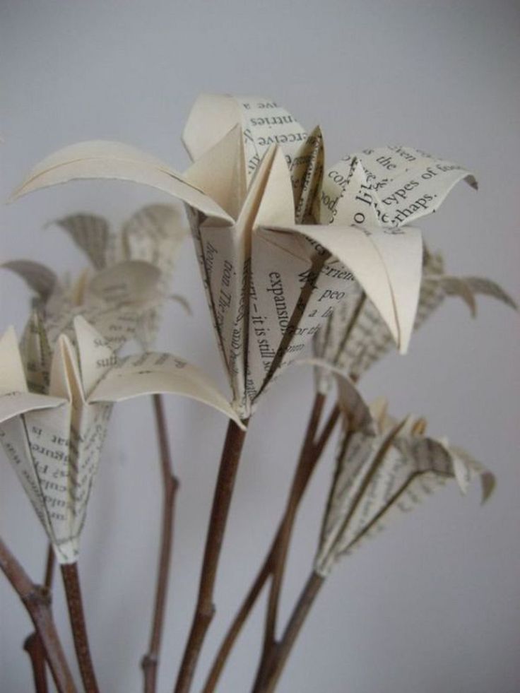 the flowers are made out of old book pages and have been placed in a vase