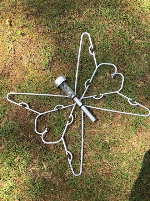 a metal object laying in the grass on top of it's side with hearts attached to it