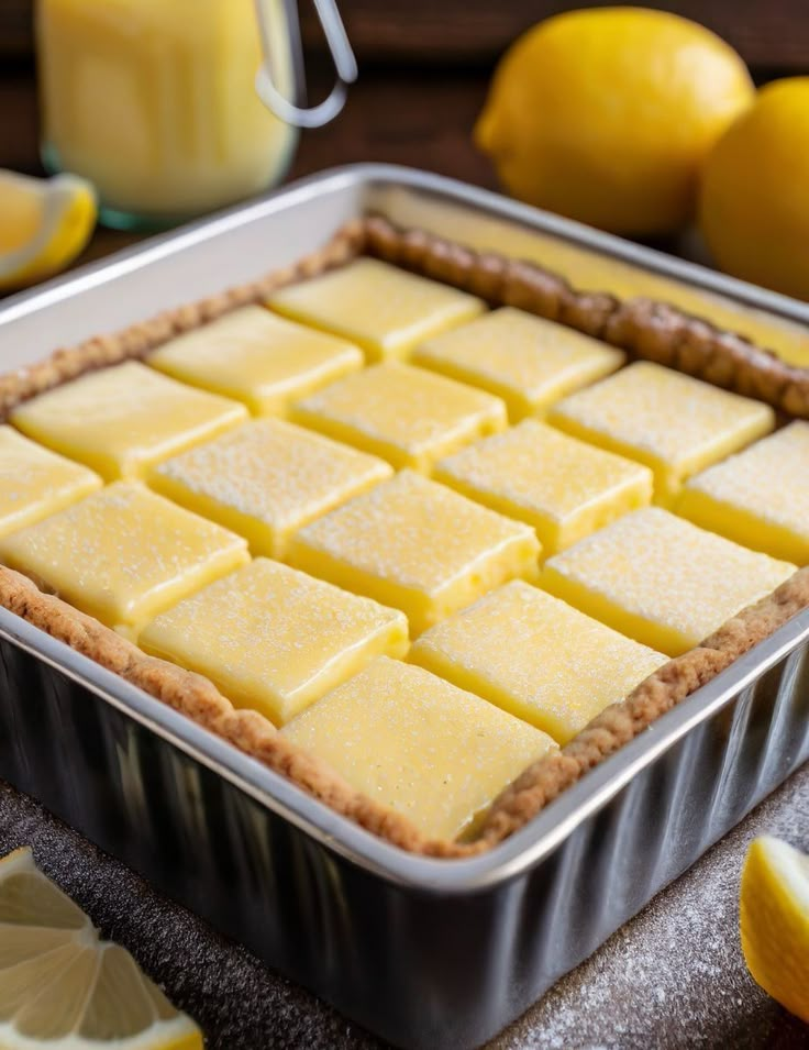 a pan filled with lemon custard tart next to sliced lemons