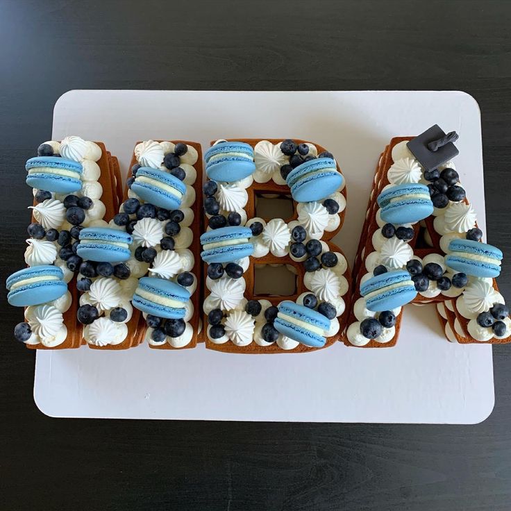 a cake shaped like the letter b on top of a white plate with blue and white frosting