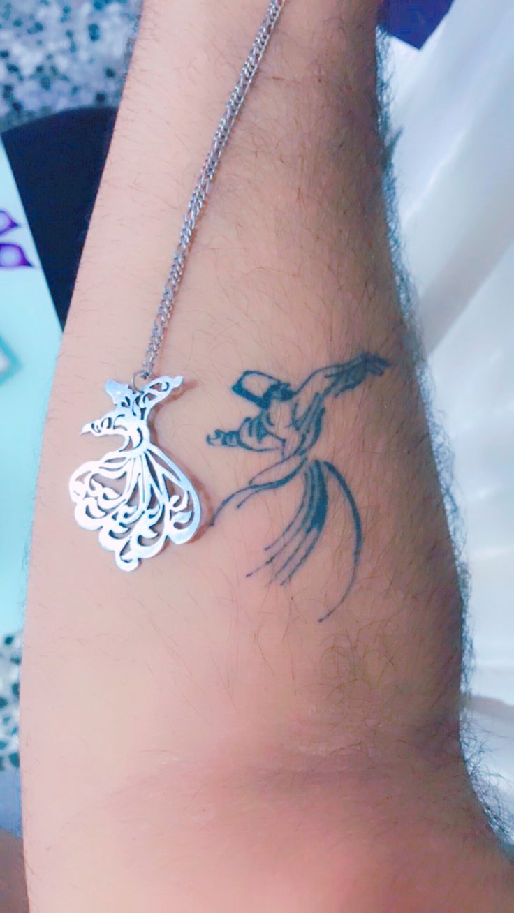 a person with a tattoo on their arm holding onto a chain that is attached to the wrist