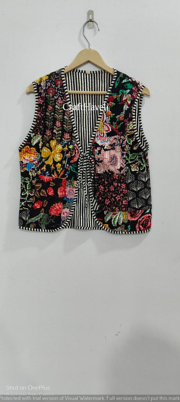 a black and white floral vest hanging on a wall