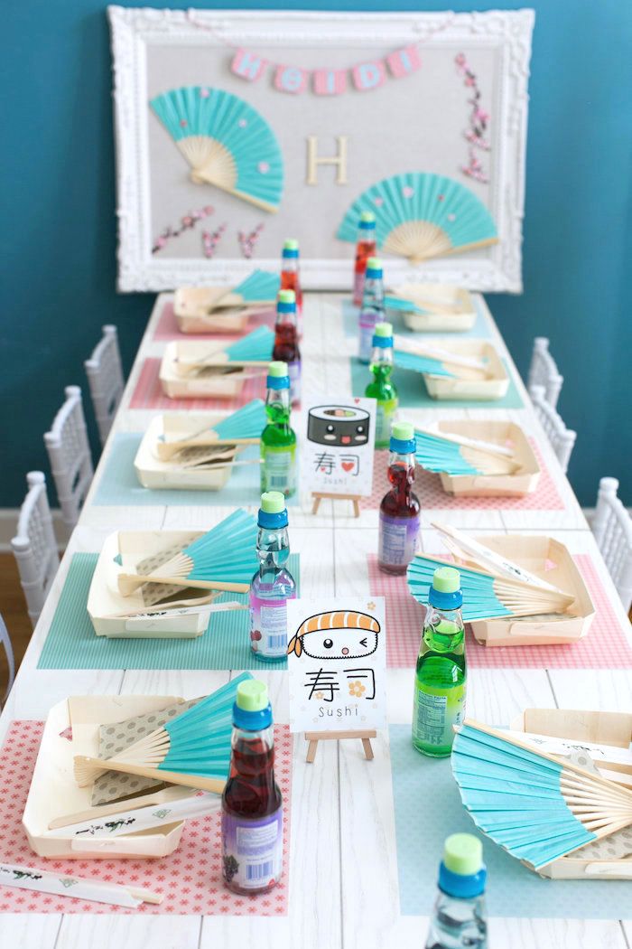 a table set up for a birthday party with paper fans and condiments on it