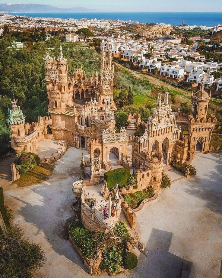 an aerial view of a castle in the middle of a town with lots of trees