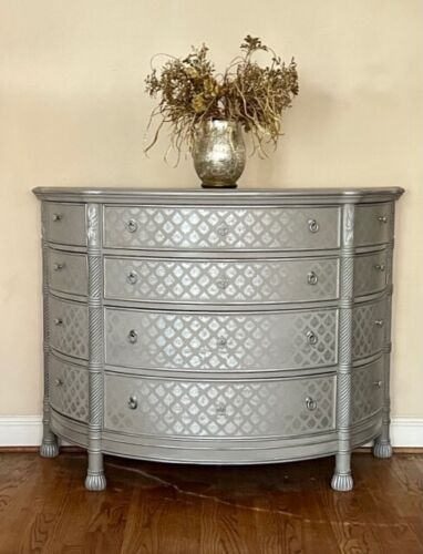 a silver dresser with flowers on top of it