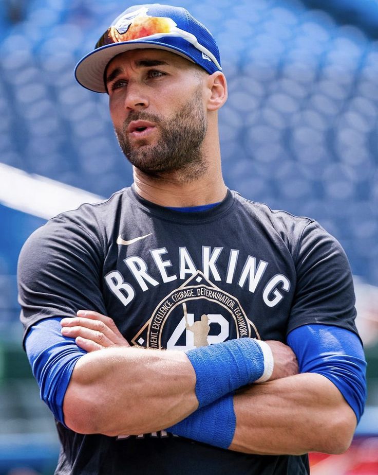 a baseball player is standing with his arms crossed