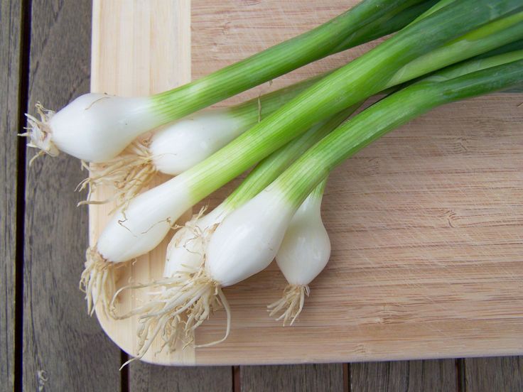 some green onions are sitting on a cutting board