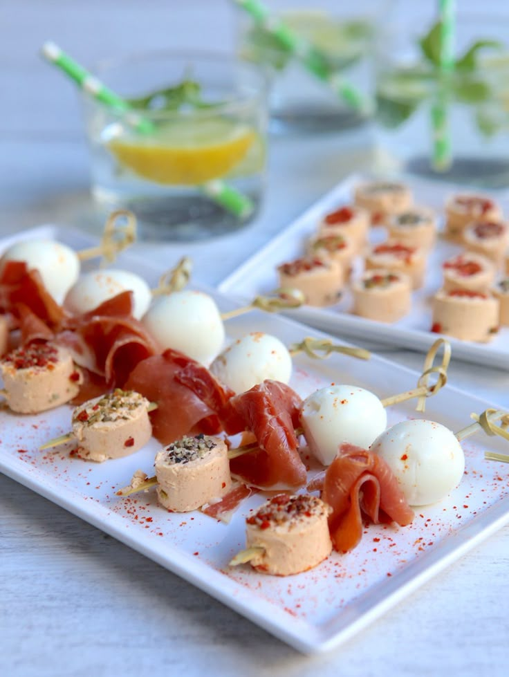 several appetizers are arranged on small white plates