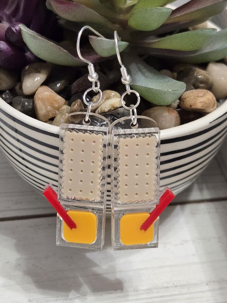 a pair of earrings sitting on top of a potted plant