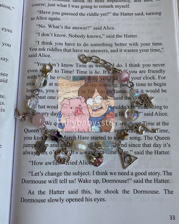 an open book with some charms attached to it's pages and the page is empty