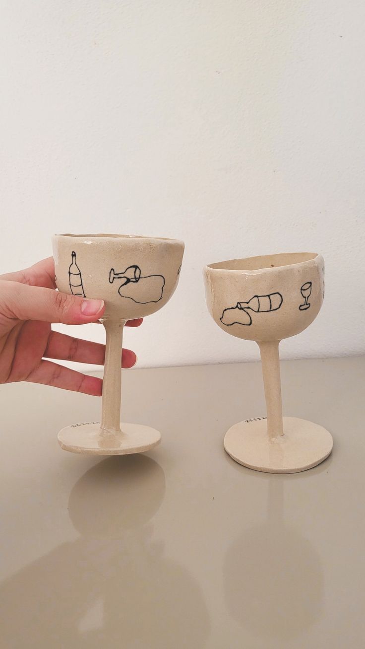 two handmade wine glasses sitting on top of a table