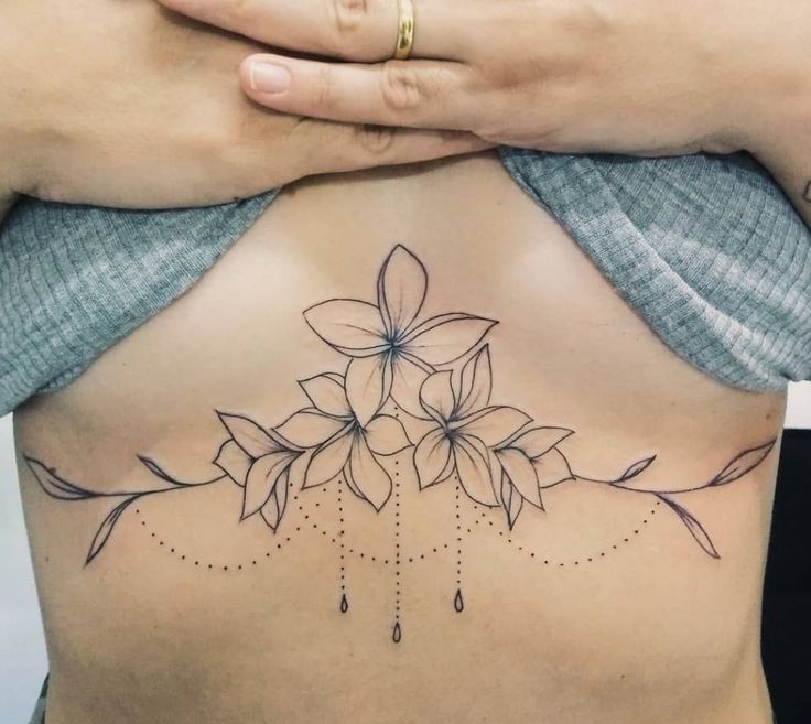 a woman's lower back tattoo with flowers on it