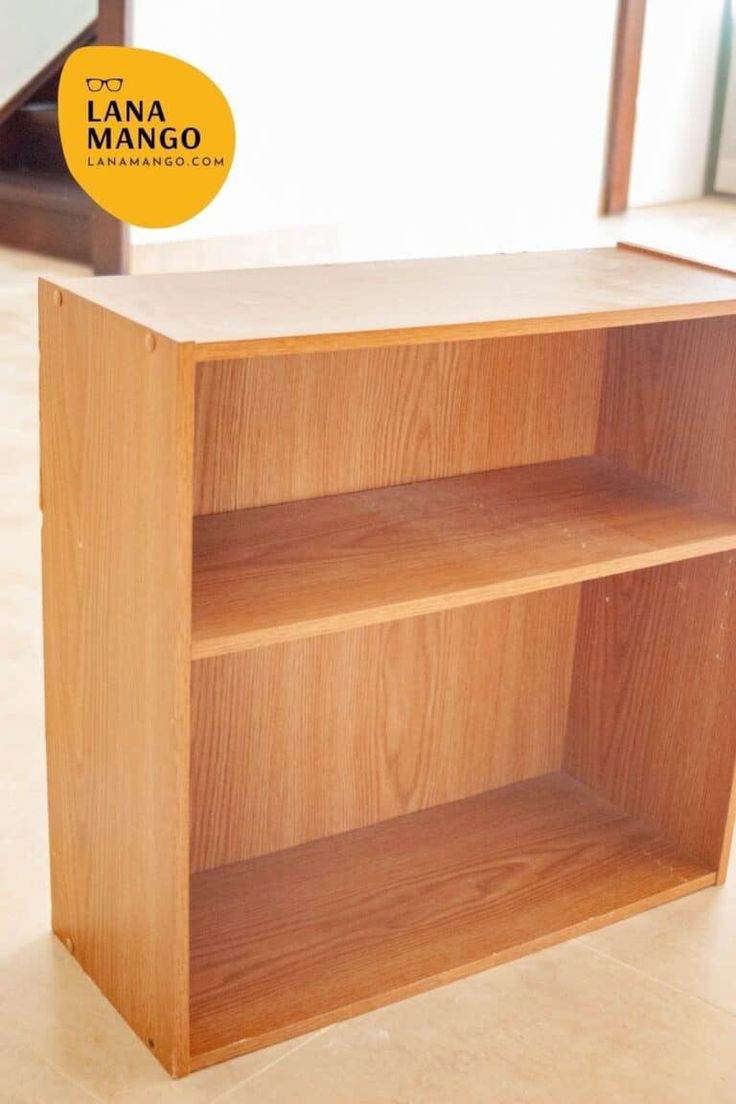 a wooden book shelf sitting on top of a tiled floor